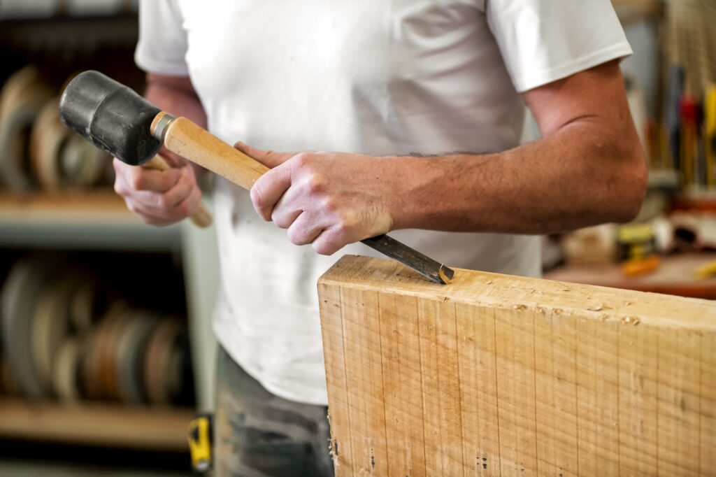 Carpenter or woodworker working with a chisel